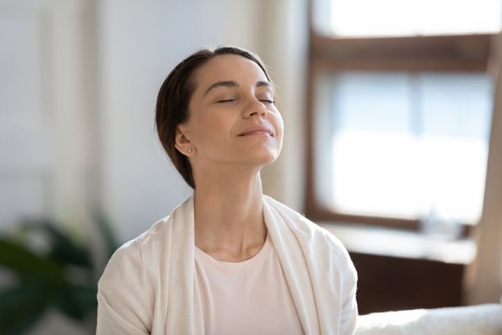 Woman peacefully breathing in clean air, highlighting indoor air quality solutions provided by HVAC services in Fort Worth, TX.